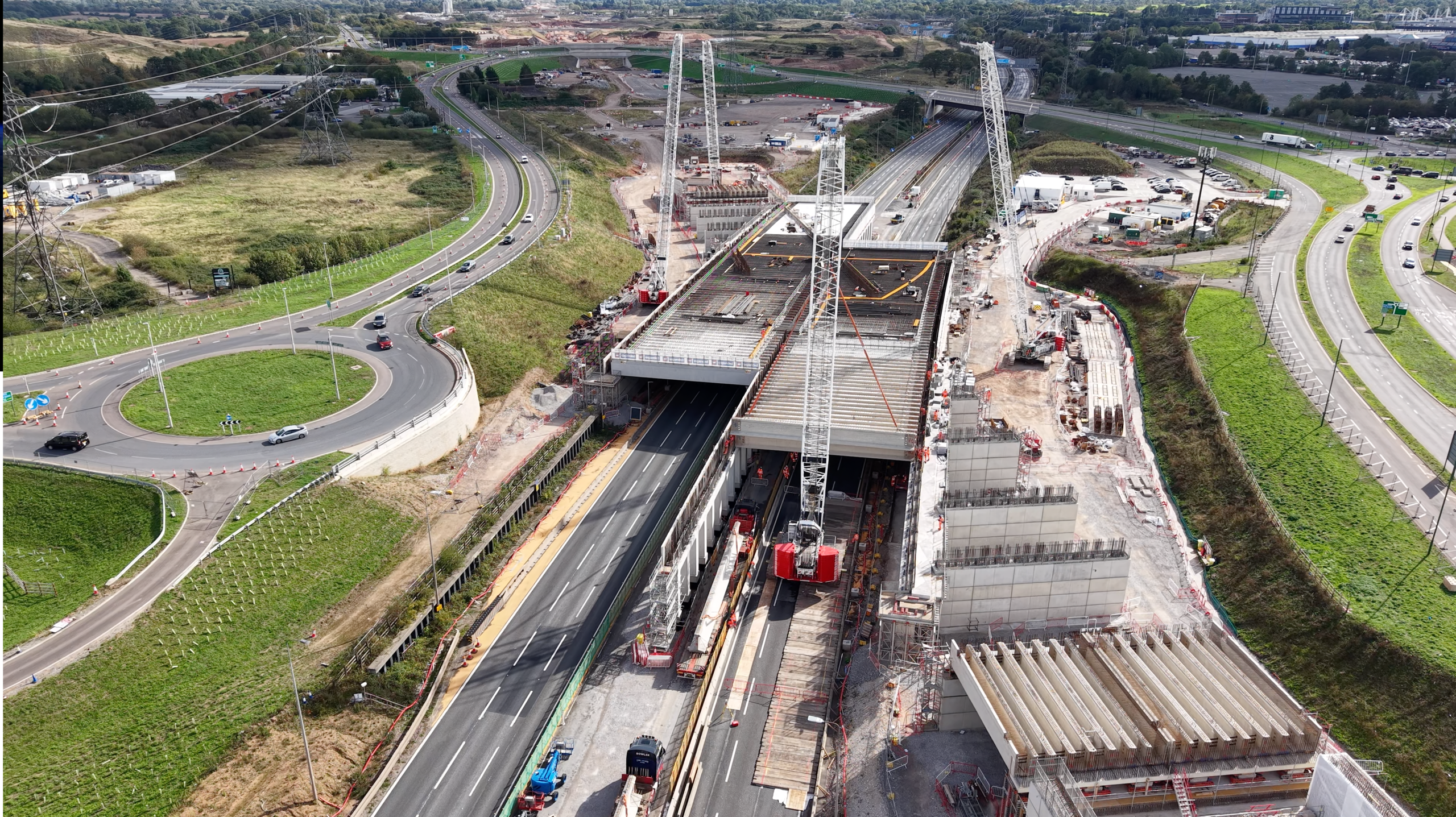 deck-beams-being-lifted-at-the-m42-twin-box-site-during-the-september-weekend-closure Aerial view of HS2’s M42 twin box construction site, with precast deck beams being installed above the motorway using large crawler cranes.